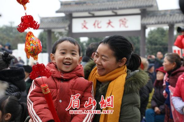 东坡区一对母子在观看文艺节目中迎接新年。.JPG