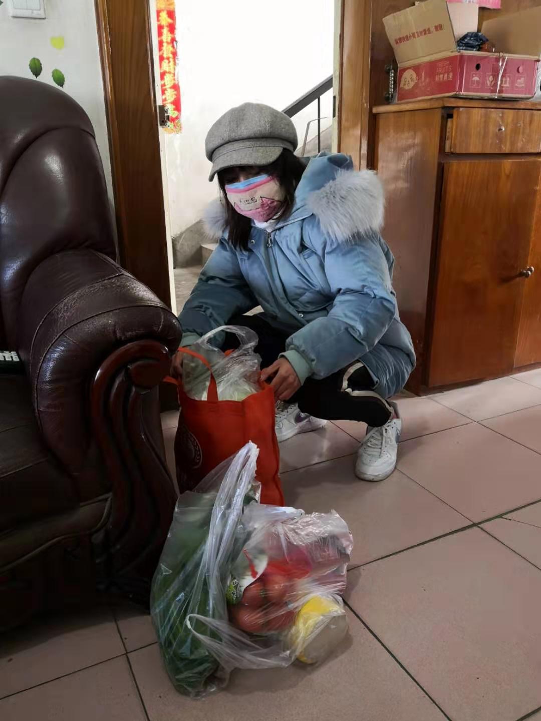 社区网格员将采购后的生活用品送到居民家中.jpg