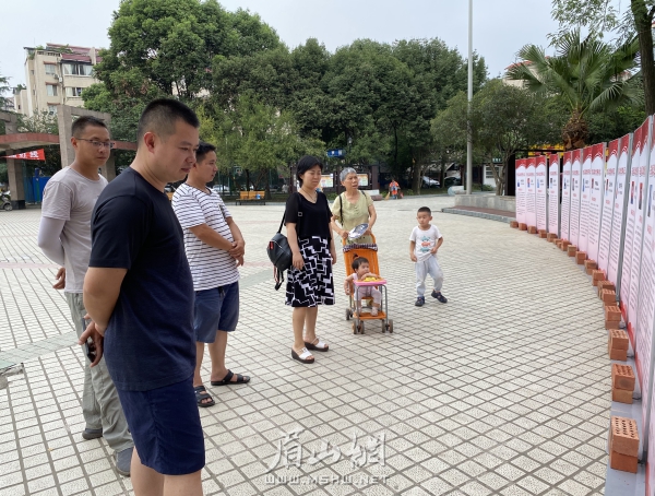 先进事迹专题展览吸引了众多市民驻足观看学习。.jpg
