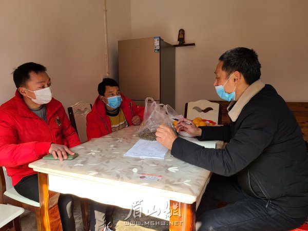 钟勇刚(右一)为建档立卡贫困户算收入账，规划未来发展。