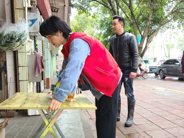 衣凤春纠正商家占道行为。