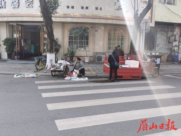  彭山区辑五路59号门前，蔬菜水果小摊贩占道经营。
