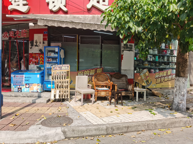 东坡区登州路70号商铺门口人行道上摆放有桌椅板凳，影响行人通行。.jpg