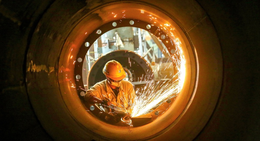 眉山天府新区中建钢构（四川）有限公司生产车间内，工人在忙碌焊接加工零部件，赶制订单。张忠苹摄