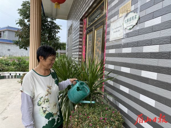 徐月华在自家庭院浇花。 徐月华在自家庭院浇花。