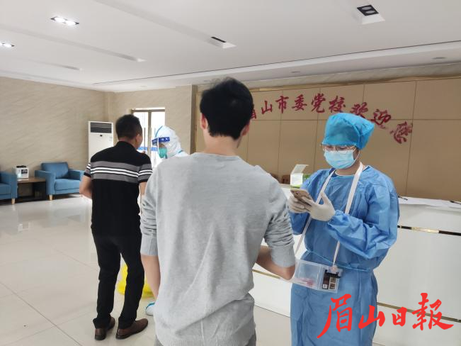 左成在市委党校学员宿舍大厅协助医护人员为留校学员做核酸检测。