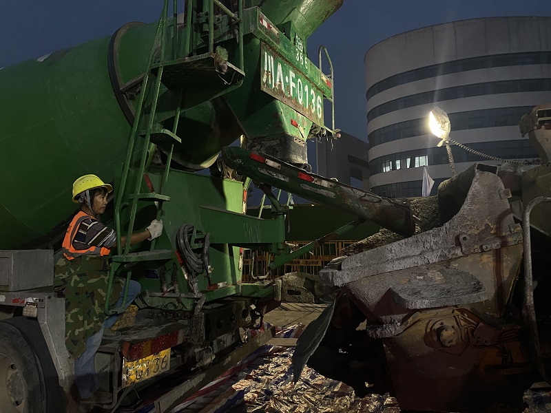  施工人员正在观察混凝土运输情况。