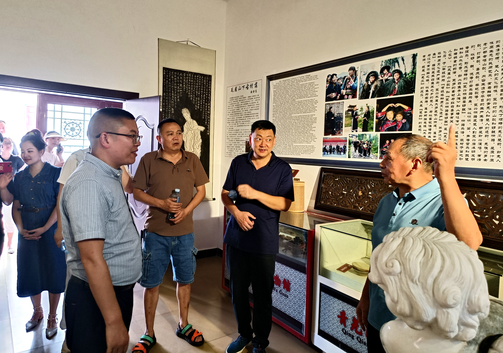 王文君（右一）向参观者介绍青羌民俗博物馆情况（资料图片）。