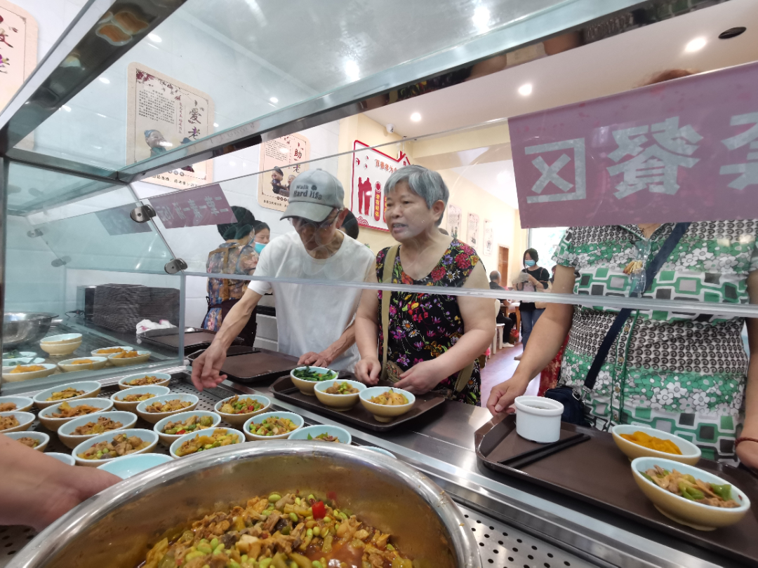 助老餐厅里老人们正在取餐。